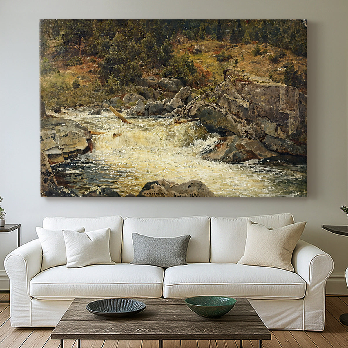 Canvas art print detailing a forested setting with stream descending over rocks, centered above a sofa as a large focal wall piece