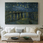 Canvas art print detailing a nocturnal landscape emphasizing contrast between lights and dark water, centered above a sofa as a large focal wall piece