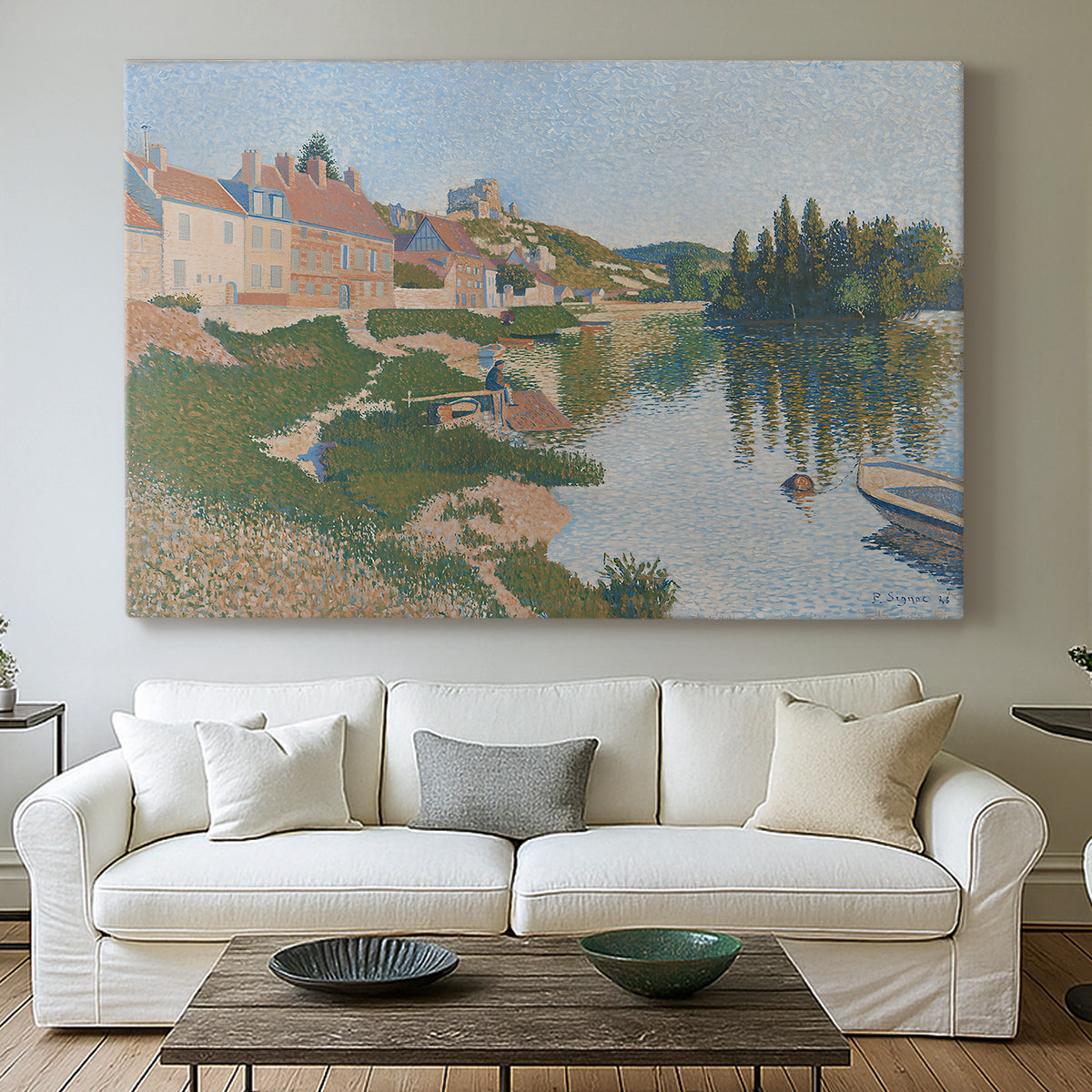 Canvas art print detailing a pointillist composition with town and natural surroundings, centered above a sofa as a large focal wall piece