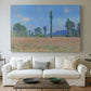Canvas art print detailing a rural field filled with red blossoms beneath open sky, centered above a sofa as a large focal wall piece