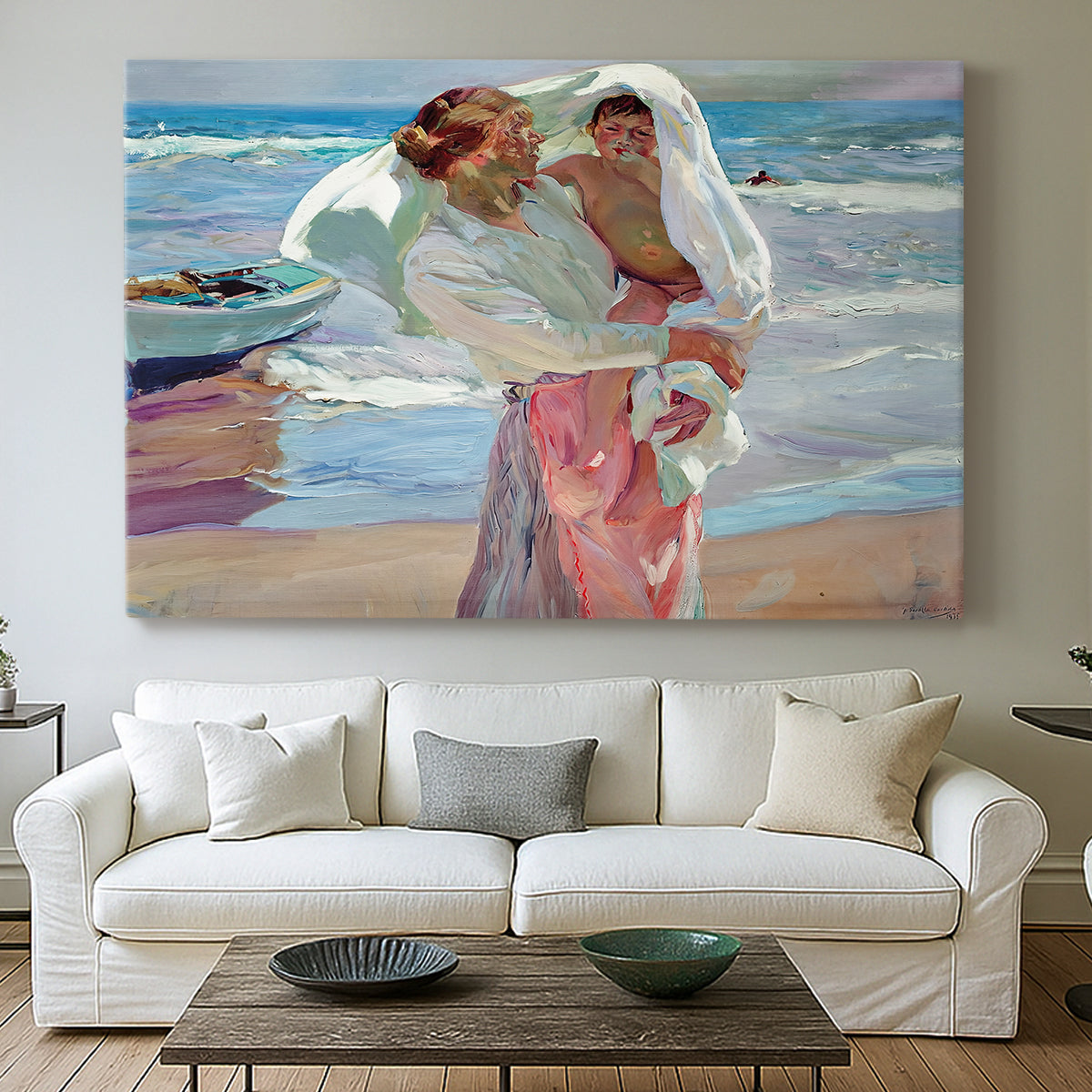 Canvas art print detailing an impressionist beach scene with soft movement and light, centered above a sofa as a large focal wall piece