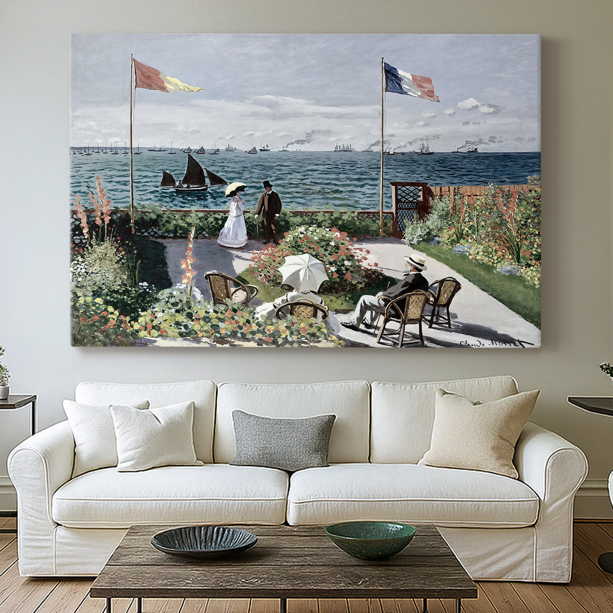 Canvas art print detailing a landscaped terrace with figures and flags near shoreline, centered above a sofa as a large focal wall piece