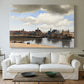 Canvas art print detailing a panoramic town scene with skyline, centered above a sofa as a large focal wall piece