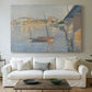Canvas art print detailing a riverside composition with boats, centered above a sofa as a large focal wall piece