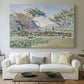Canvas art print detailing a landscape with village and meadow, centered above a sofa as a large focal wall piece