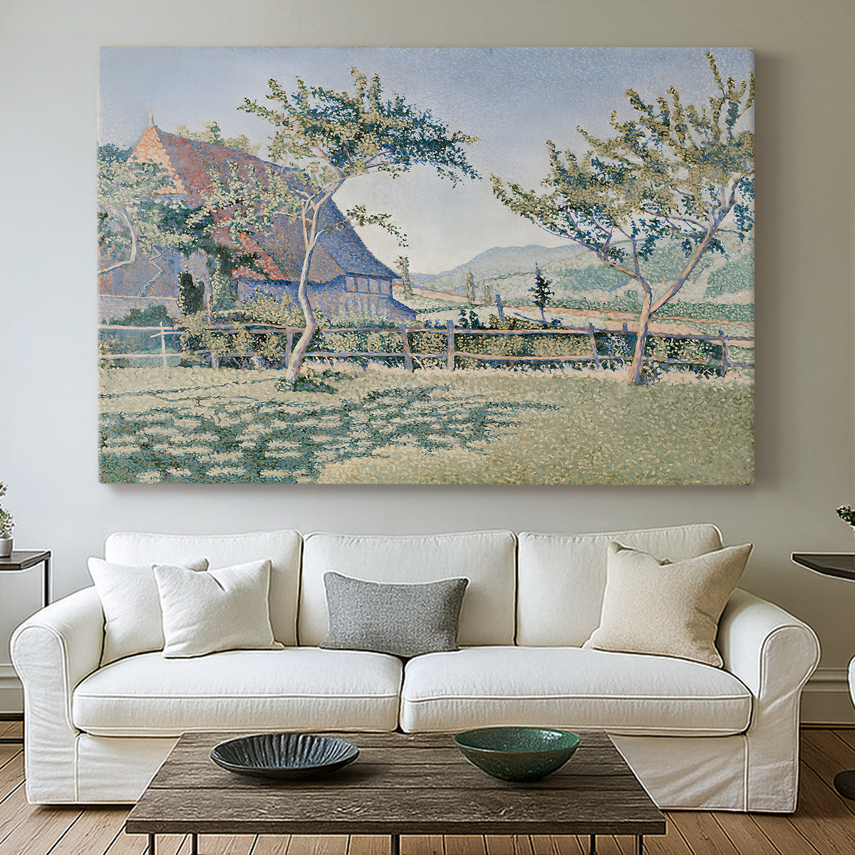 Canvas art print detailing a landscape with village and meadow, centered above a sofa as a large focal wall piece