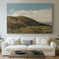 Canvas art print detailing a peaceful rural vista with greenery, water, and architectural landmark, centered above a sofa as a large focal wall piece