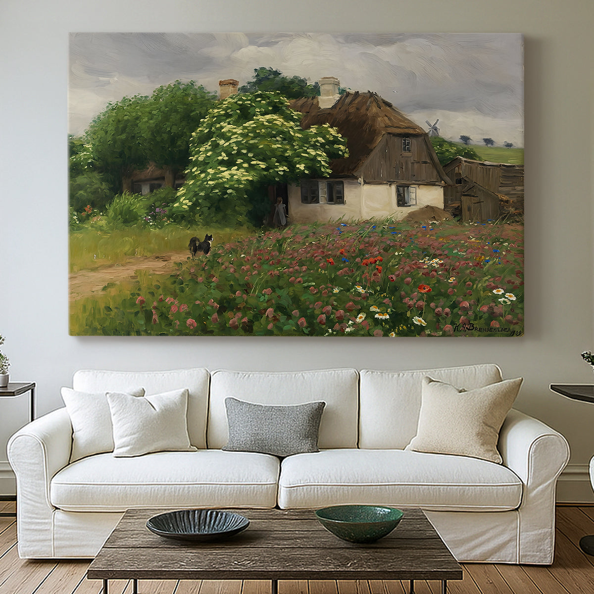 Canvas art print detailing a peaceful farmhouse view with natural vegetation, centered above a sofa as a large focal wall piece