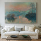 Canvas art print detailing an atmospheric landscape combining cold tones and warm sky, centered above a sofa as a large focal wall piece