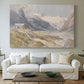 Canvas art print detailing a natural landscape with human presence among mountains, centered above a sofa as a large focal wall piece