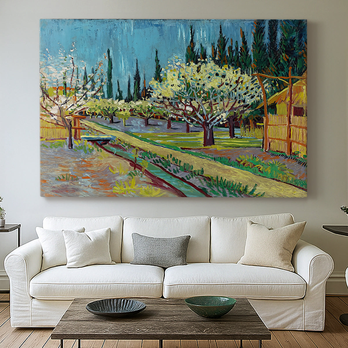 Canvas art print detailing a countryside composition combining flowering trees and structure, centered above a sofa as a large focal wall piece