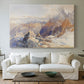 Canvas art print detailing a rugged mountain pass scene with distant peaks, centered above a sofa as a large focal wall piece