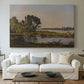Canvas art print detailing a countryside scene with flowing water and greenery, centered above a sofa as a large focal wall piece