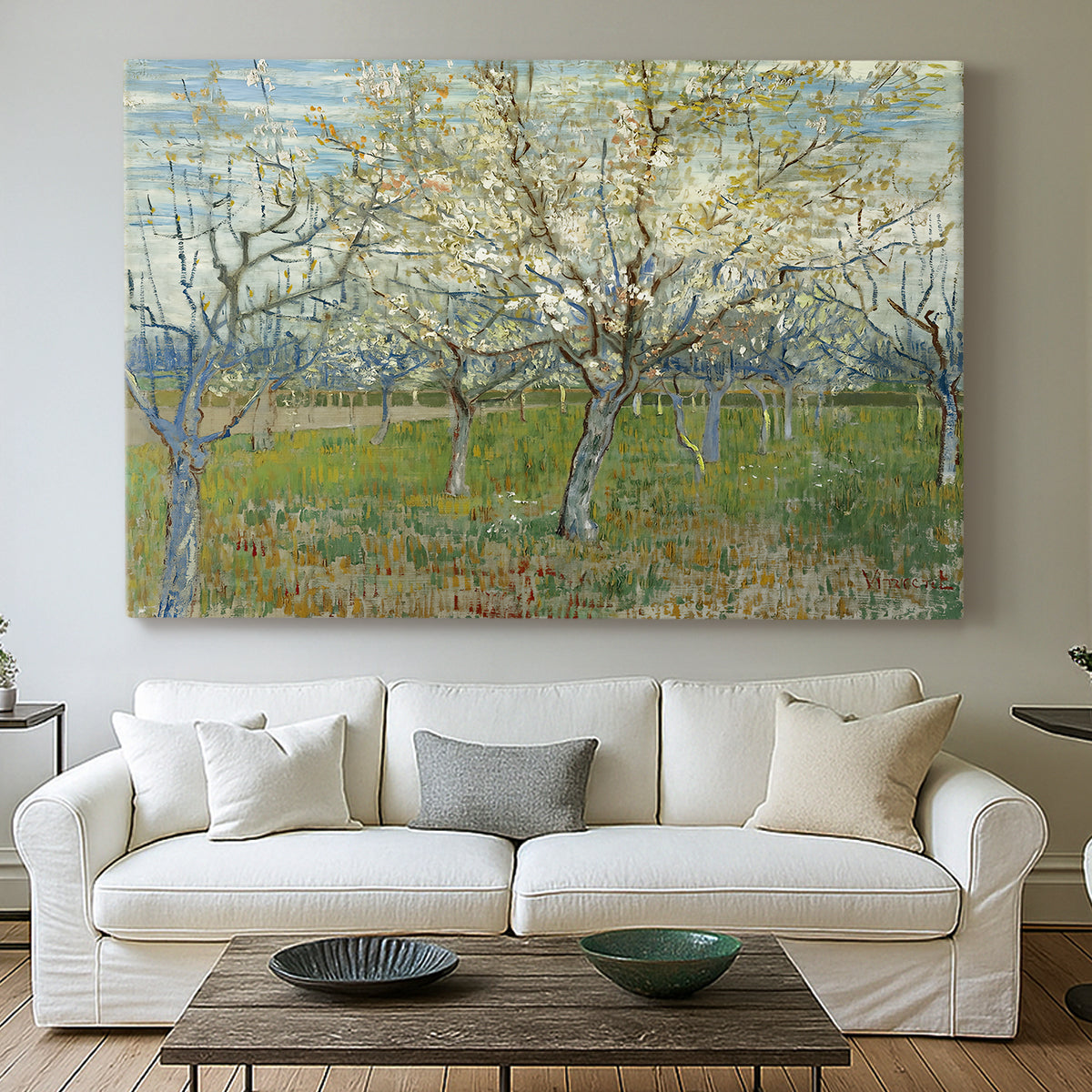 Canvas art print detailing a stylized orchard composition with delicate tones, centered above a sofa as a large focal wall piece