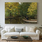 Canvas art print detailing a tranquil nature setting with lone figure by water, centered above a sofa as a large focal wall piece