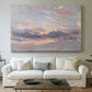 Canvas art print detailing a landscape focused on cloud formations, centered above a sofa as a large focal wall piece