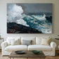 Canvas art print detailing a storm-driven seascape with dark clouds and rough surf, centered above a sofa as a large focal wall piece
