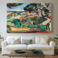 Canvas art print detailing a stylized coastal landscape with buildings and trees, centered above a sofa as a large focal wall piece