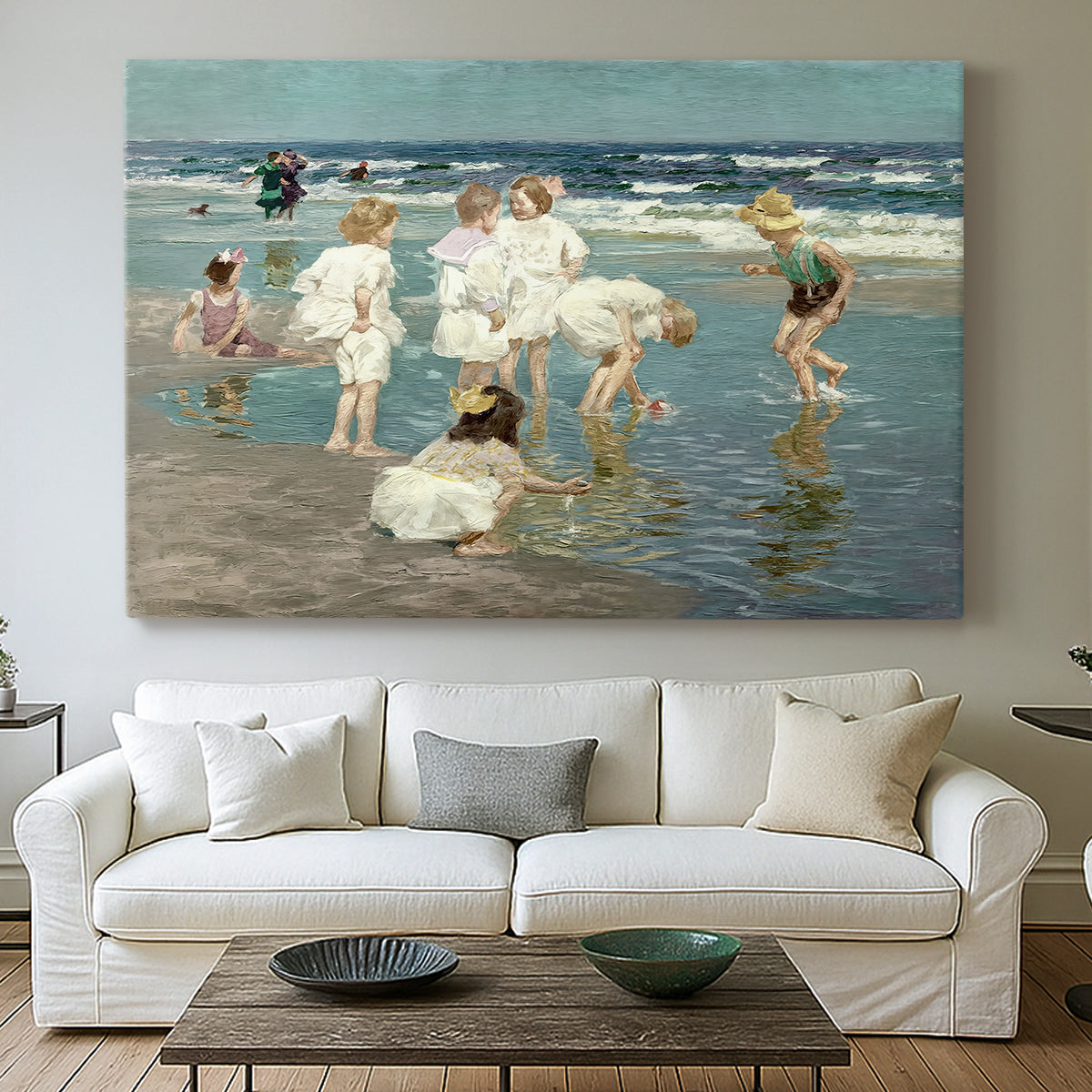 Canvas art print detailing a lively shoreline scene with people gathered in surf, centered above a sofa as a large focal wall piece