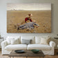 Canvas art print detailing a solitary figure collapsed in natural setting, centered above a sofa as a large focal wall piece