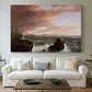 Canvas art print detailing an expansive seascape with light breaking through clouds, centered above a sofa as a large focal wall piece
