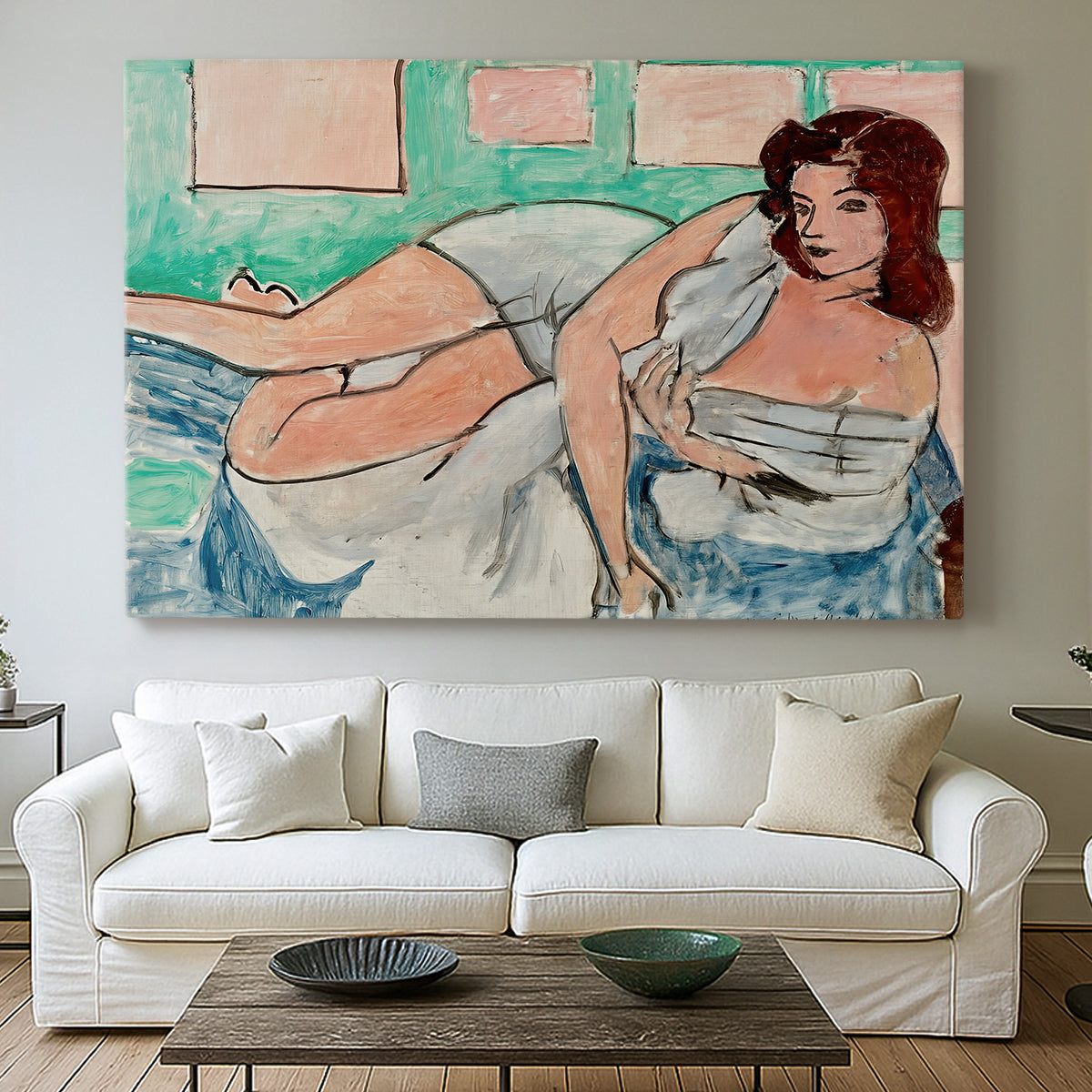 Canvas art print detailing a stylized female figure in a relaxed pose with drapery, centered above a sofa as a large focal wall piece