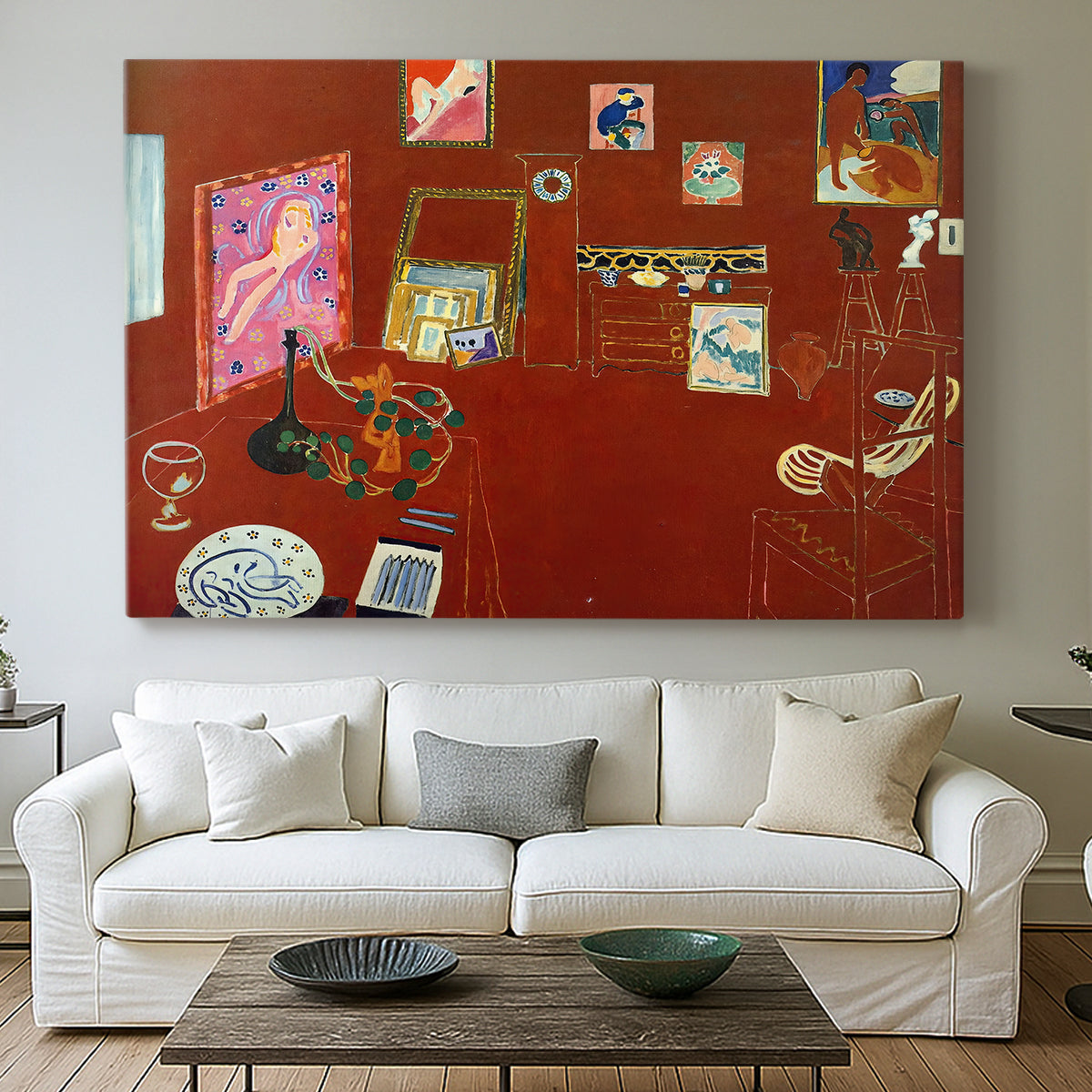 Canvas art print detailing a stylized artist studio dominated by red, centered above a sofa as a large focal wall piece