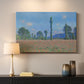 Canvas art print detailing a rural field filled with red blossoms beneath open sky, mounted in a softly lit interior space