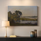 Canvas art print detailing a countryside scene with flowing water and greenery, mounted in a softly lit interior space