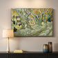 Canvas art print detailing a landscape featuring tall trunks and figures in shaded area, mounted in a softly lit interior space