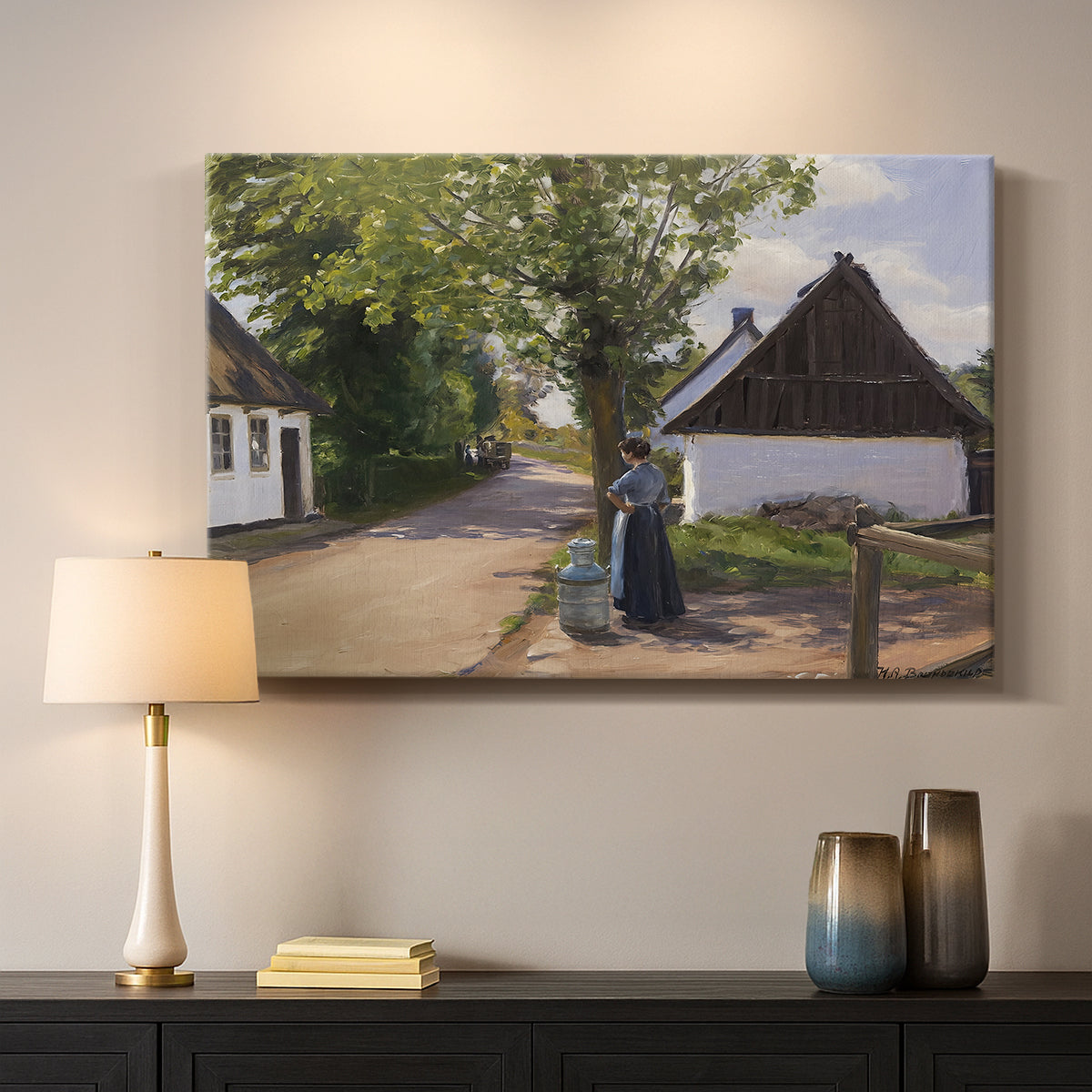 Canvas art print detailing a village setting with people and traditional architecture, mounted in a softly lit interior space