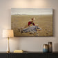 Canvas art print detailing a solitary figure collapsed in natural setting, mounted in a softly lit interior space