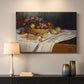 Canvas art print detailing a tabletop composition with fruit and subtle shadows, mounted in a softly lit interior space
