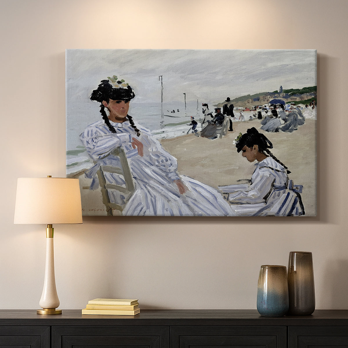Canvas art print detailing a coastal leisure scene with figures looking out to sea, mounted in a softly lit interior space