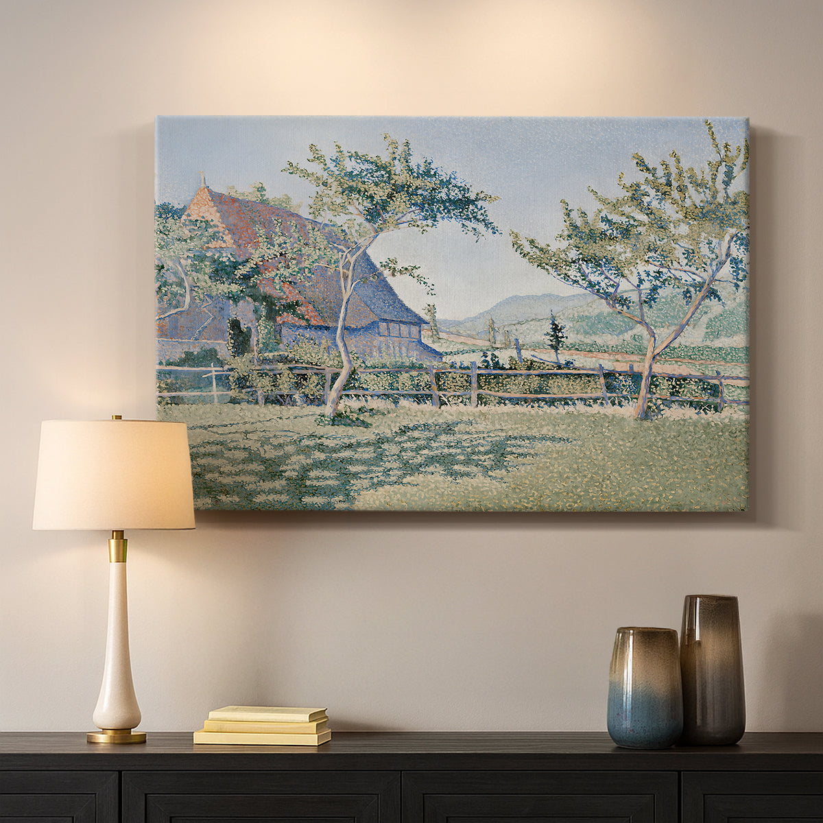 Canvas art print detailing a landscape with village and meadow, mounted in a softly lit interior space