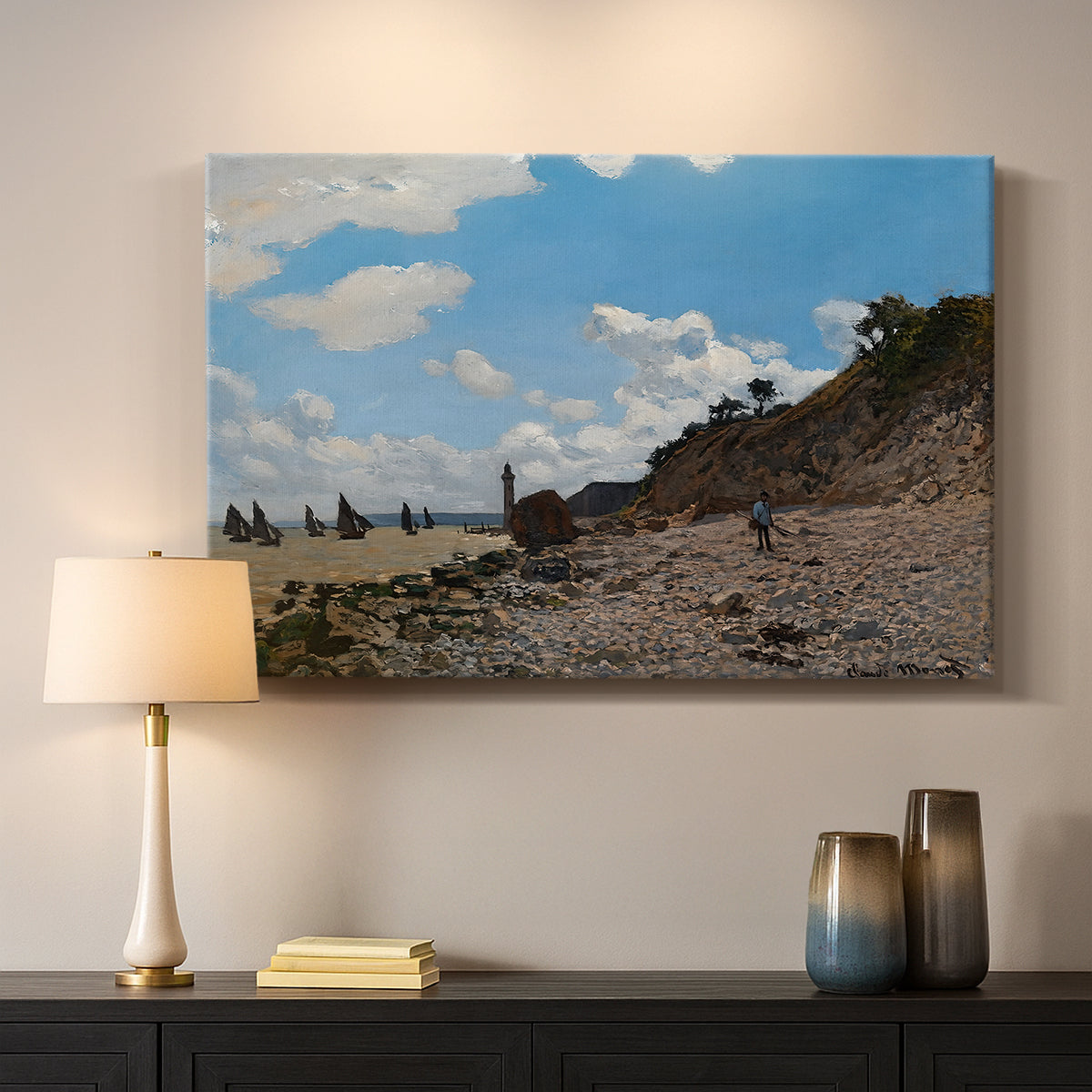Canvas art print detailing a coastal landscape with boats and people along shore, mounted in a softly lit interior space