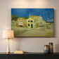 Canvas art print detailing a cityscape centered on structure and surrounding roadway, mounted in a softly lit interior space