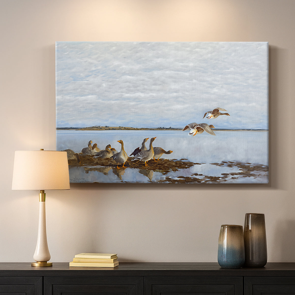 Canvas art print detailing a flock of geese positioned along marshy terrain, mounted in a softly lit interior space