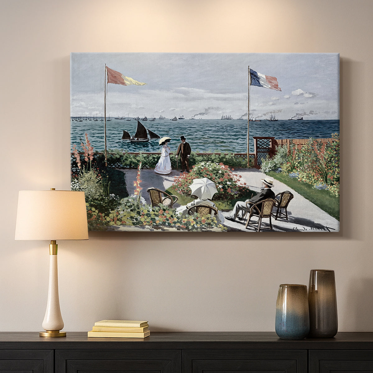 Canvas art print detailing a landscaped terrace with figures and flags near shoreline, mounted in a softly lit interior space