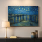 Canvas art print detailing a stylized night composition with river and celestial elements, mounted in a softly lit interior space