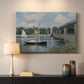 Canvas art print detailing a scenic riverscape with architecture and nautical activity, mounted in a softly lit interior space