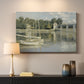 Canvas art print detailing a riverside view with architecture and nautical activity, mounted in a softly lit interior space