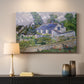 Canvas art print detailing a stylized composition featuring houses and landscape, mounted in a softly lit interior space