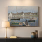 Canvas art print detailing a tranquil river setting with sailboats and shoreline, mounted in a softly lit interior space