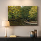 Canvas art print detailing a tranquil nature setting with lone figure by water, mounted in a softly lit interior space