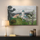 Canvas art print detailing a colorful scene of a villa among trees and vegetation, mounted in a softly lit interior space