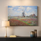 Canvas art print detailing a rural scene with patterned rows of flowers and windmill, mounted in a softly lit interior space