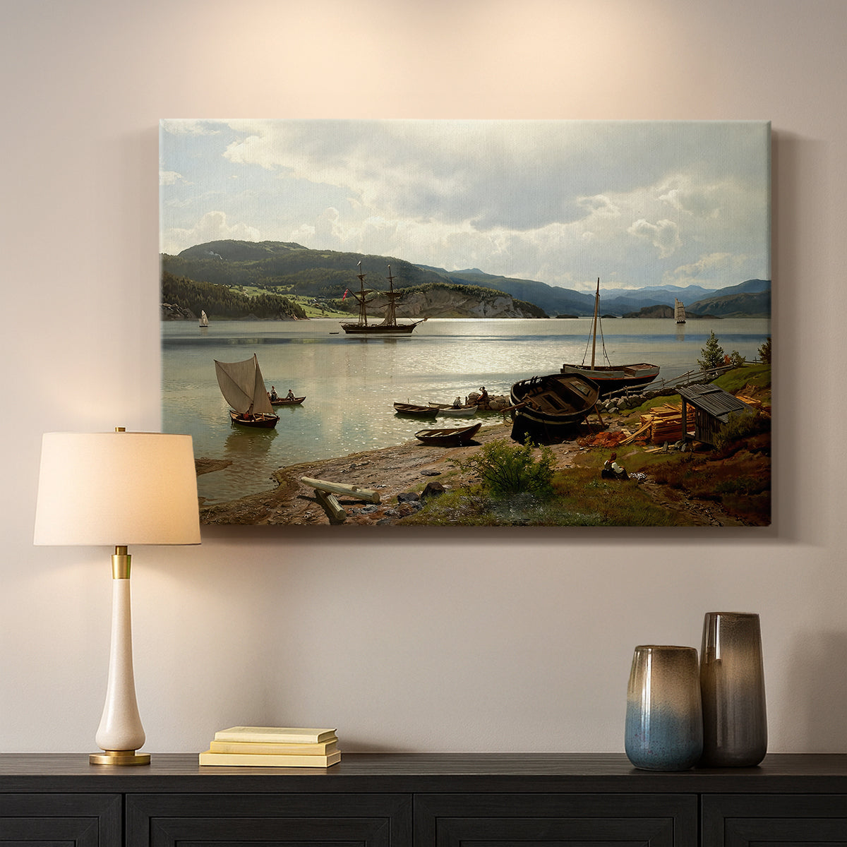 Canvas art print detailing a serene shoreline view with boats and human presence, mounted in a softly lit interior space