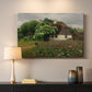 Canvas art print detailing a peaceful farmhouse view with natural vegetation, mounted in a softly lit interior space