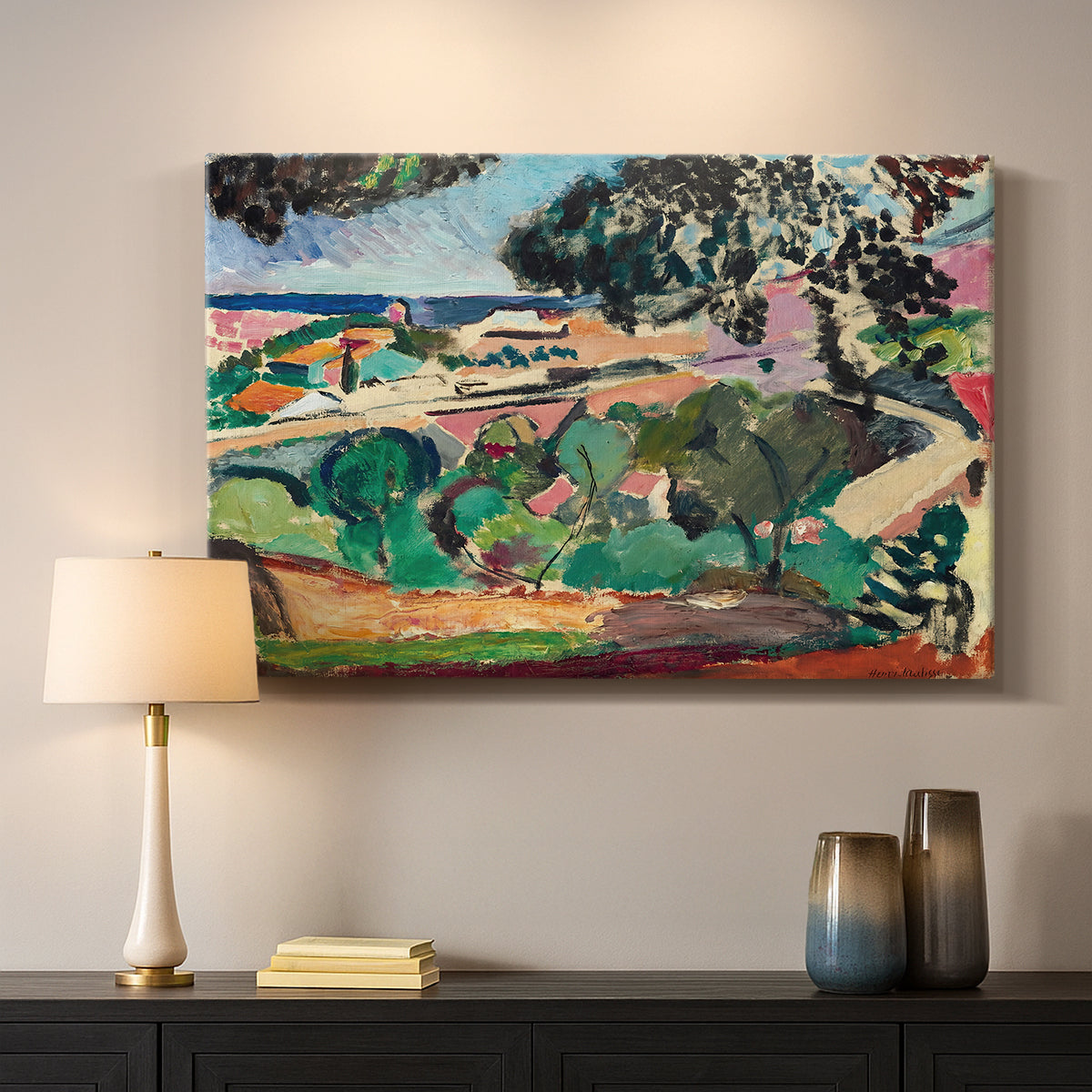Canvas art print detailing a stylized coastal landscape with buildings and trees, mounted in a softly lit interior space